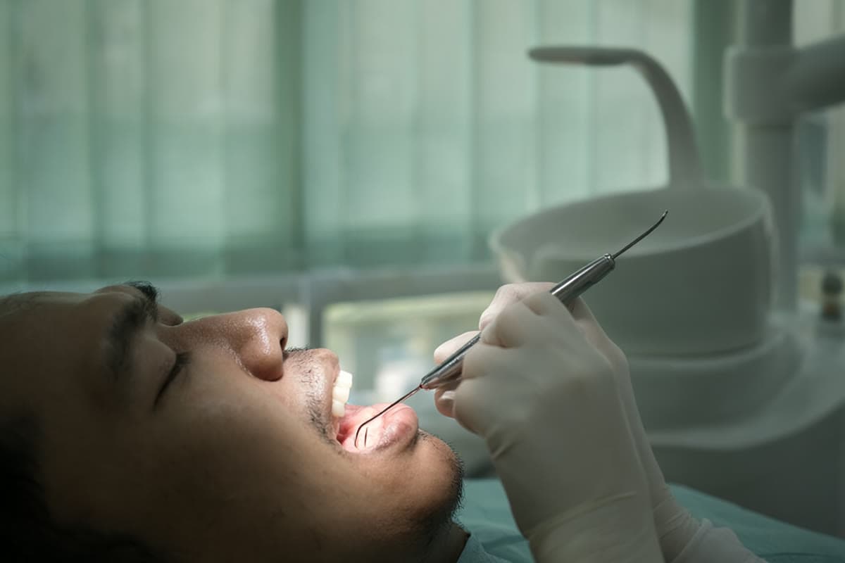 A dentist measuring a patient's gum pocket with a periodontal probe